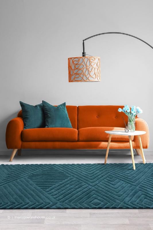 A deep teal textured carpet grounding a warm orange sofa in a modern living room
